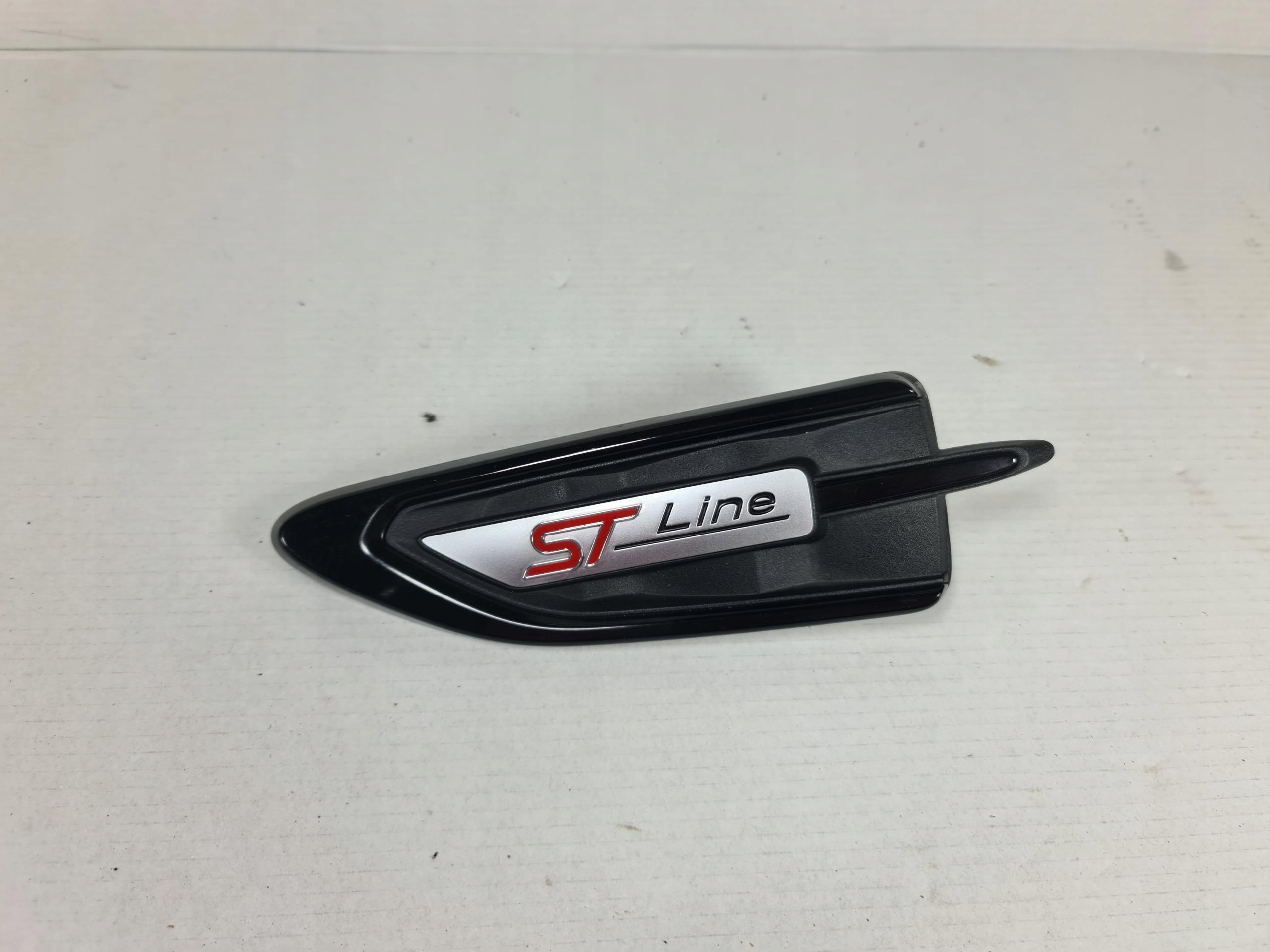 GJ54-16C217-CA - KUGA MK2 ST ЗНАЧОК ЭМБЛЕМА КРЫЛА ЛЕВЫЙ ЧЕРНЫЙ